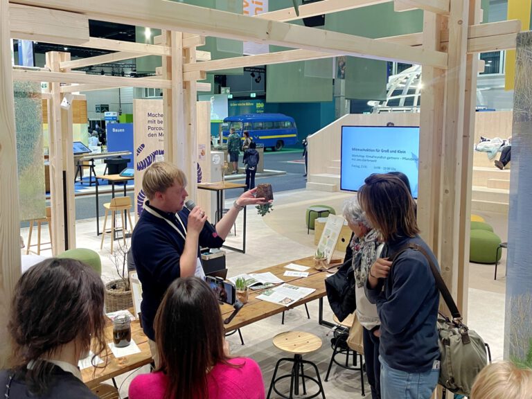 Der GartenJan im Gespräch mit Besucherinnen am Messestand